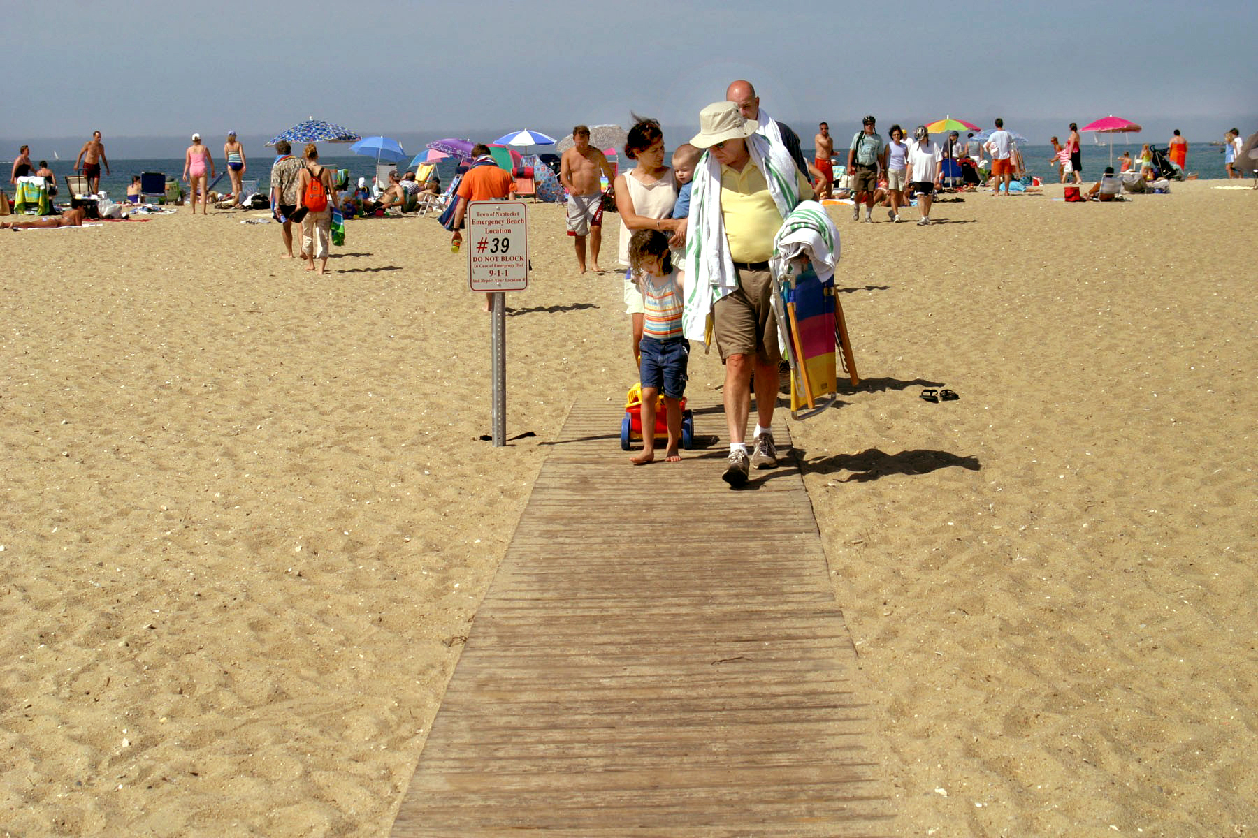 People walking on a beach board walk